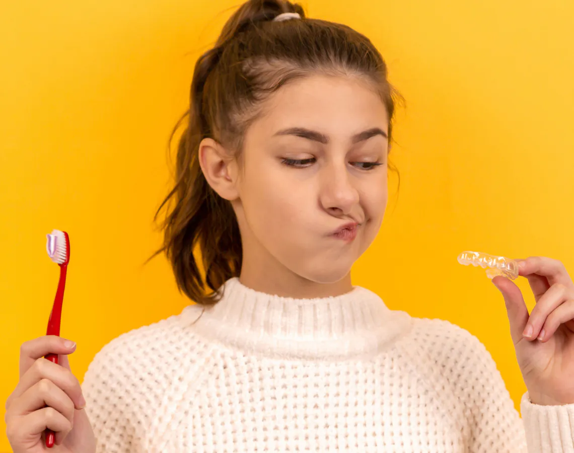 Paciente con cepillo de dientes y contenciones